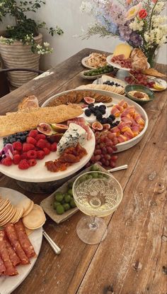 a wooden table topped with lots of plates and bowls filled with different types of food