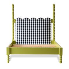 a green bed frame with a black and white checkered pillow on the top of it