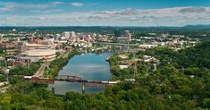 an aerial view of a city with a river running through it and bridge in the foreground