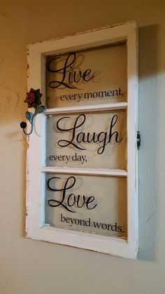 a window with some words on it and a flower in the window sill next to it