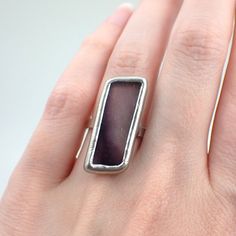 "Transparent, frosted purple stained glass ring edged in silver. The sterling silver wire band is approximately US size 6.5. This is a one of a kind ring. Ring Size: US 6.5 / UK N Center Glass Size: 1 3/16\" x 1/2\" Each item by Faerie Glass Jewelry is 100% uniquely hand-crafted with quality materials that are lead-free. NOTE - All photographs are taken in effort to best represent the actual product. Color of actual jewelry may vary slightly from photographs." Stained Glass Ring, Purple Stained Glass, Rhombus Shape, Glass Ring, Glass Gems, Glass Rings, Glass Jewelry, Silver Wire, Rings Statement