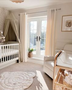 a baby's room with a crib, rocking chair and window