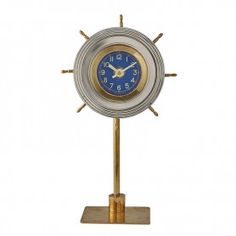 a gold and silver clock on a stand with blue numbers in the middle, against a white background