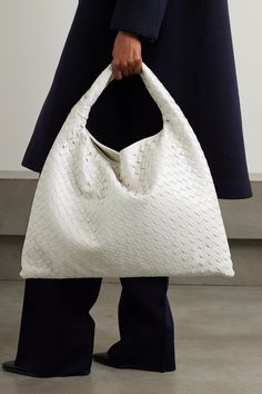 This beautifully crafted tote is undoubtedly Bottega Veneta - it's woven from strips of glossy white leather using the house's signature intrecciato technique. Defined by its slouchy shape, it's sized to hold all your essentials and has a curved shoulder strap. White Top Handle Bag With Intrecciato Weave, Designer White Bags With Intrecciato Weave, White Rectangular Bag With Intrecciato Weave, Modern White Bag With Intrecciato Weave, Elegant White Intrecciato Weave Bag, Elegant White Bag With Intrecciato Weave, Designer White Shoulder Bag With Braided Handles, Luxury White Shoulder Bag With Intrecciato Weave, Luxury White Intrecciato Weave Shoulder Bag