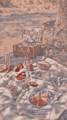 a picnic with bread, fruit and jams on the table in front of a tree