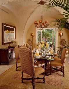 a dining room table with chairs and a potted plant in the middle of it