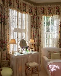 a bedroom with floral curtains and white furniture