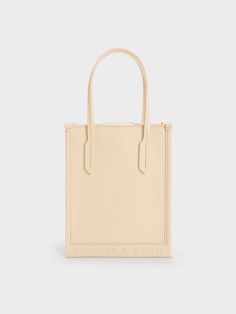 Featuring a versatile all-beige finish, this neutral iteration of our geometric tote bag is a must-have to complete any capsule collection. The sleek and slim rectangular silhouette will add a polished feel to your every ensemble, while the elongated double handles make it easy and comfortable to carry. Perfectly sized to keep all your daily essentials with ample room to spare, this tote bag is as functional as it is stylish. Denim Tote Bags, Size Chart For Kids, White Tote, Charles Keith, Capsule Collection, Printables Kids, Black Tote Bag, Green Bag, Chain Bags