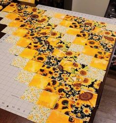 the table is covered with yellow and black sunflowers, which have been cut into squares