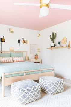 a bed room with a neatly made bed and two stools on the floor next to it