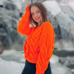 a woman in an orange sweater posing for a photo