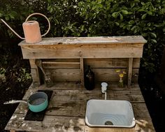 a wooden table topped with a sink next to a bottle