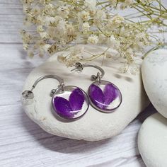 These beautiful, handcrafted earrings with real dry purple flower petals are the perfect gift for her, whatever the occasion may be. -Amazing feature -  Removable charm to transform your earrings into classical style. Gently remove the charm from the hoop and enjoy new possibilities. Ideal birthday gift for young women or beautiful addition to your jewellery collection.  I know that you value quality and safety. That's why I only use the highest quality metals to avoid skin allergies. Specially selected and hand-picked real flowers make this jewellery more unique and special. Simply add to basket, add your free gift note and checkout! Meaningful gift giving, without the stress.  WHAT'S INCLUDED  These bespoke earrings comes in the jewellery box ready to be gifted. Polishing Cloth & Care In Handmade Purple Earrings For Her, Silver Sterling Flower Earrings With Pressed Flowers, Silver Sterling Silver Earrings With Pressed Flowers, Purple Sterling Silver Jewelry With Flower Charm, Sterling Silver Jewelry With Purple Flower Charm, Purple Round Hoop Earrings As Gift, Purple Round Hoop Earrings For Gift, Elegant Silver Earrings With Pressed Flowers, Silver Pressed Flowers Drop Earrings