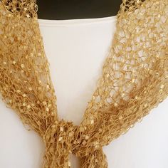 This is a light weight very thin and delicate golden ladder yarn shawl which is hand made and can be worn for a wedding or any other formal occasions.  It is perfect on an elegant dress or worn with a jacket and will upgrade your look in a unique way. It has many options to be worn . It is so special because of the color of gold so it is very elegant but can fit so many outfits and it a wonderful addition to whatever you wear. I love knitting with this special ladder yarn to make unique scarves. Formal Shawl, Gold Shawl, Yarn Shawl, Gold Scarf, Evening Accessories, Elegant Shawl, Evening Shawls, Triangle Shawls, Scarf Casual