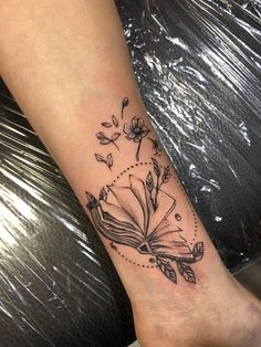 a woman's arm with a book and flowers tattoo on the left side of her leg