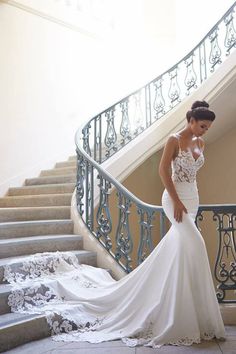 a woman in a wedding dress standing on some stairs