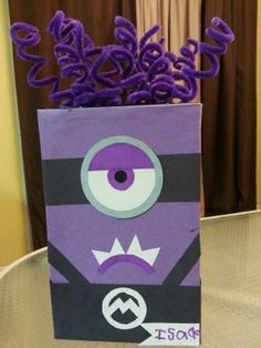 a purple bag with an evil face on it sitting on top of a glass table