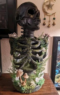 a fake human head with plants growing out of it on a table next to pictures