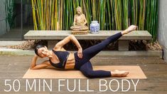 a woman is doing yoga on a mat in front of a buddha statue and bamboo trees