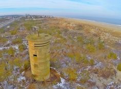 an aerial view of a large tower in the middle of a field with snow on it