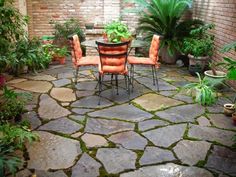 an outdoor patio with tables and chairs surrounded by greenery