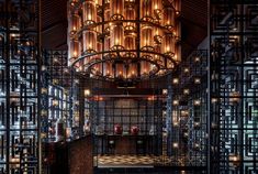 a large chandelier hanging from the ceiling in a room filled with glass bottles