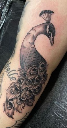 a black and white peacock with a parachute on it's head is shown in this tattoo