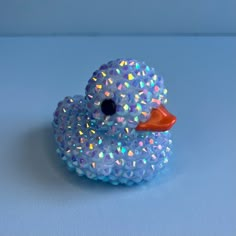 a blue rubber ducky with multicolored sprinkles on it's head