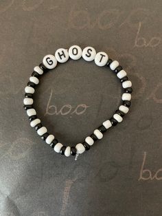 a black and white beaded bracelet with the word ghost spelled in small letters on it