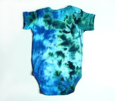 This short sleeve tie-dye baby bodysuit is dyed in beautiful ocean colors of turquoise, aqua, blues, and greens in a spattered pattern. The photos show the front and back views. Available in sizes: Newborn, 6 months, 12 months, 18 months, and 24 months. SizeBody WidthBody Length Newborn7 in13 in. 6 months;;8 1/2 in14 1/2 in. 12 months10 in16 in. 18 months11 in16 in. 24 months11 in18 1/2 in. The bodysuit is a Rabbit Skins brand, short sleeve, 100% cotton, nice quality. Lap shoulder sleeves, three Multicolor Short Sleeve Onesie For Summer, Casual Blue Onesie For Summer, Blue Cotton Onesie For Summer, Green Fitted Casual Onesie, Casual Blue Summer Onesie, Multicolor Short Sleeve Cotton Onesie, Multicolor Cotton Short Sleeve Onesie, Green Short Sleeve Cotton Onesie, Green Cotton Short Sleeve Onesie