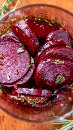 sliced beets in a glass bowl with herbs