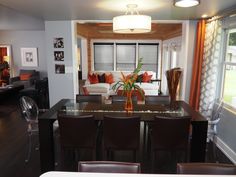 a dining room table with chairs and a vase filled with flowers on top of it