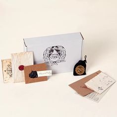 an open box containing stamps, envelopes and other items on a white table top