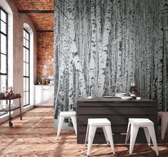 a dining room table with two stools next to it and a brick wall behind it