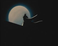 the silhouette of a batman standing on top of a hill in front of a full moon