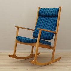 a wooden rocking chair with blue upholstered fabric on the seat and backrest