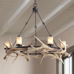 a chandelier with antlers hanging from it's sides in a room