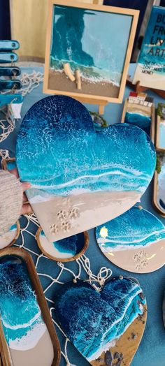 blue and white heart shaped cakes are on display at a table with other decorative items