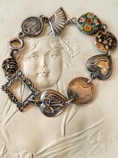 a close up of a necklace on a white surface with an image of a woman's face