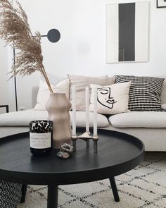 a living room with white couches and black coffee table in front of the couch