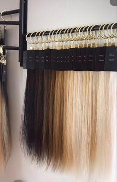 two blonde and one brown hair hanging on a rack