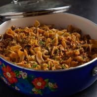 a blue pot filled with pasta and meat