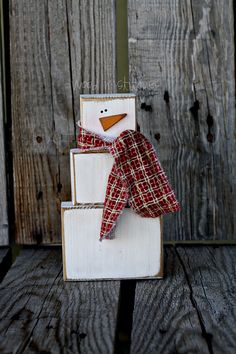 a wooden block with a snowman sitting on top of it