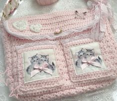 a pink crocheted purse with pictures of cats on the front and side, sitting on a lace doily