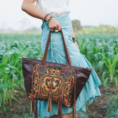 "This shoulder bag is the perfect addition to enhance your offerings. It features a tribal hmong pattern, cotton lining, adorned with black leather tassel as decoration. This shoulder bag will highlight your fabulous offerings. We buy materials from Hmong market and we design and sew by hand. Some of the bags we modify to improve the product. The Hmong tribes live in the North of Thailand and have origins from the Tibetan area of China. You may not receive the exact bag picture here, As the fabr Bohemian Shoulder Bag With Removable Pouch For Travel, Bohemian Hobo Bag For Travel, Embroidered Tote Bag For Travel, Multicolor Embroidered Pouch Shoulder Bag For Travel, Handwoven Tote Bag For Festival, Daily Use Hand-stitched Tote Shoulder Bag, Handwoven Rectangular Festival Bag, Embroidered Brown Hobo Tote Bag, Hand-stitched Tote Shoulder Bag For Daily Use