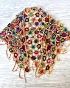 Embrace the natural beauty of the outdoors with this intricately hand-crocheted triangle wrap, adorned with charming, colorful, floral patterns and playful fringe details. Generously sized for easy layering, this shawl is the perfect companion for festival days or cool, breezy evenings. Drape it effortlessly over your favorite outfits to add a light, cozy layer with an air of vintage romance. Crafted from soft, lightweight yarn, this shawl flows elegantly across your shoulders, offering a touch Bohemian Hand Knitted Shawl For Festival, Bohemian Festival Hand Knitted Shawl, Spring Bohemian Crochet Shawl, Bohemian Hand-knitted Yarn Shawl, Bohemian Shawl With Crochet Lace, Bohemian Shawl For Summer Festival, Brown Crochet Bohemian Shawl, Bohemian Crochet Lace Shawl For Spring, Bohemian Crochet Lace Shawl For Summer