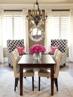 a dining room table with chairs and a chandelier hanging from it's ceiling