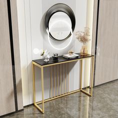 a white and gold console table with a round mirror on the wall next to it