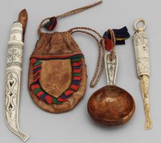 an assortment of antique items are displayed on a white surface, including a wooden bowl and spoon