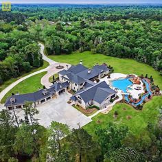 an aerial view of a large house with a pool in the middle and lots of trees around it